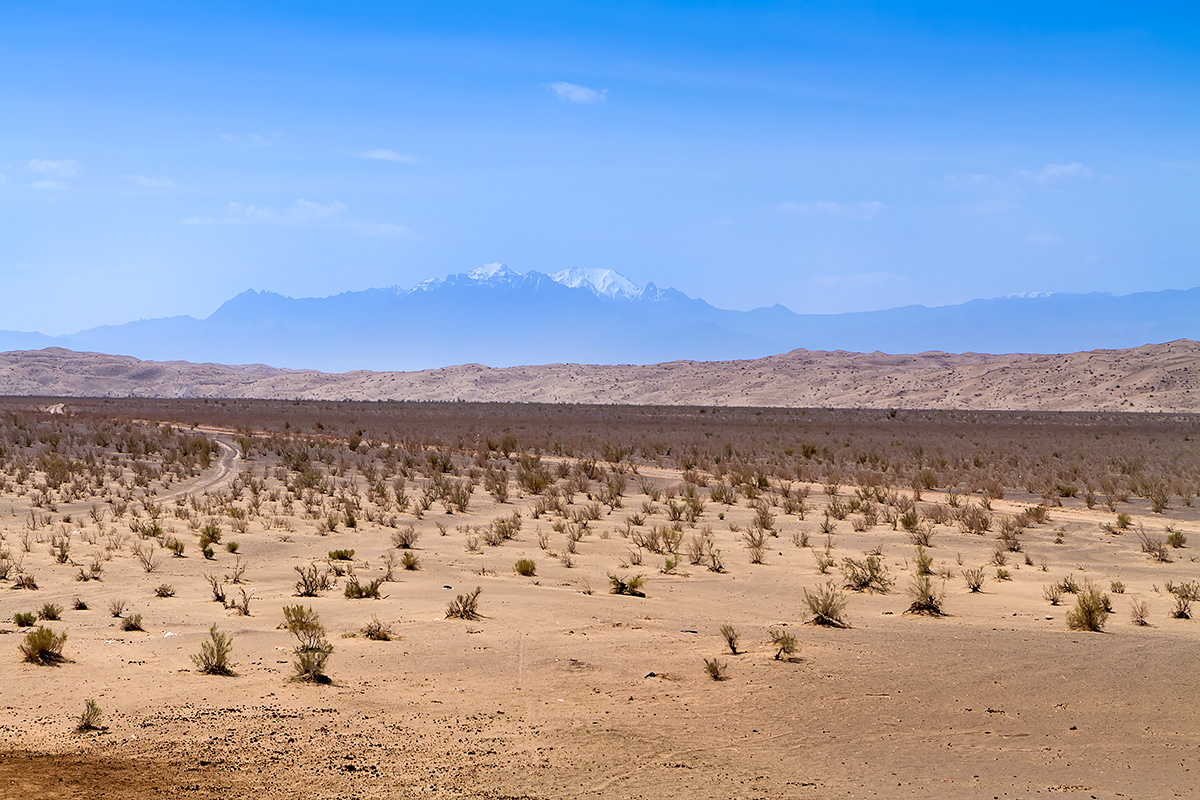 From the desert plain and over dunes there are snow-capped mountains to be seen. Kuh-e Karkas rises 3.899 m ASL.  The distance to the peak is over 70 kilometres.
